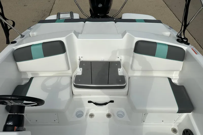 Slide: The Image of 2026 Tahoe T16 boat interior with gray and teal seating, steering wheel, and cup holders. - 6