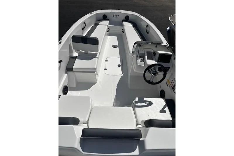 Slide: The Image of 2026 Tahoe T18 boat interior with seating and steering console, featuring a sleek white design. - 2