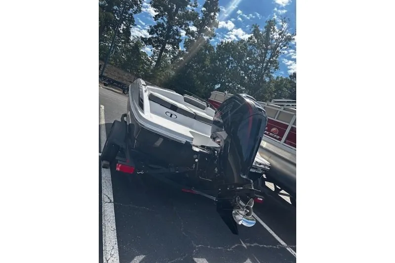 Slide: The Image of 2026 Tahoe T18 boat on trailer, parked outdoors under a sunny sky. - 6