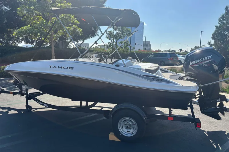 Slide: The Image of 2026 Tahoe T16 boat with Mercury outboard motor on a trailer in a parking lot. - 1