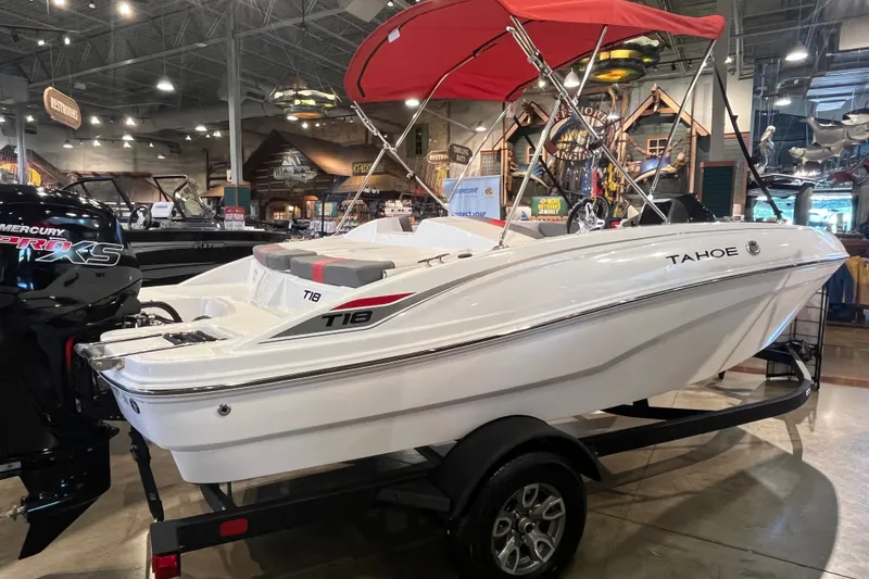 Slide: The Image of 2026 Tahoe T18 boat with red canopy displayed indoors on a trailer. - 3
