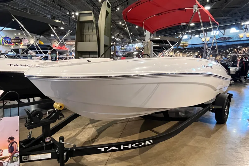 Slide: The Image of 2026 Tahoe T18 boat with red canopy on display in a showroom. - 1