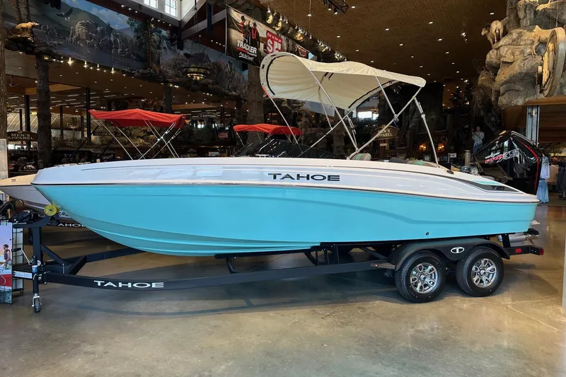 Slide: The Image of 2026 Tahoe T21 boat in showroom, light blue hull, canopy, on trailer. - 0