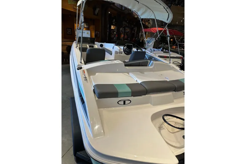 Slide: The Image of 2026 Tahoe T21 boat with canopy and seating, displayed indoors. - 3