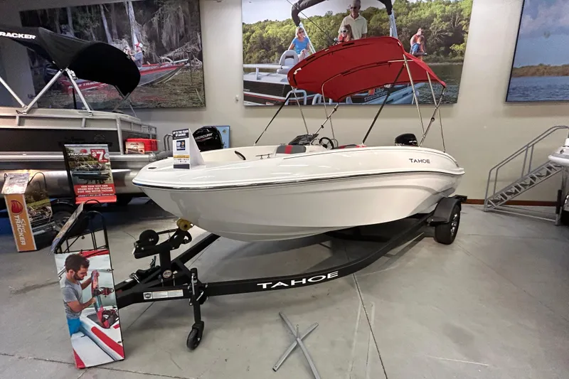 The Image of 2026 Tahoe T18 boat on display in showroom with red canopy and promotional materials. - 0