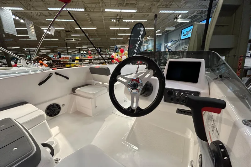 Slide: The Image of 2026 Tahoe T18 boat interior with steering wheel and control panel in showroom. - 4