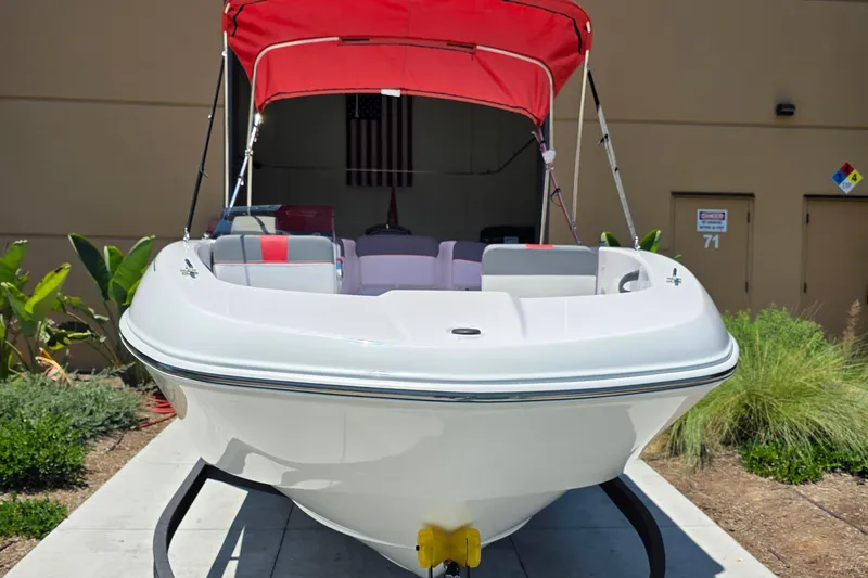 The Image of 2026 Tahoe T18 boat with red canopy, parked outdoors on a sunny day. - 0