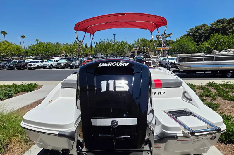 Slide: The Image of 2026 Tahoe T18 boat with Mercury 115 engine, red canopy, parked outdoors. - 2