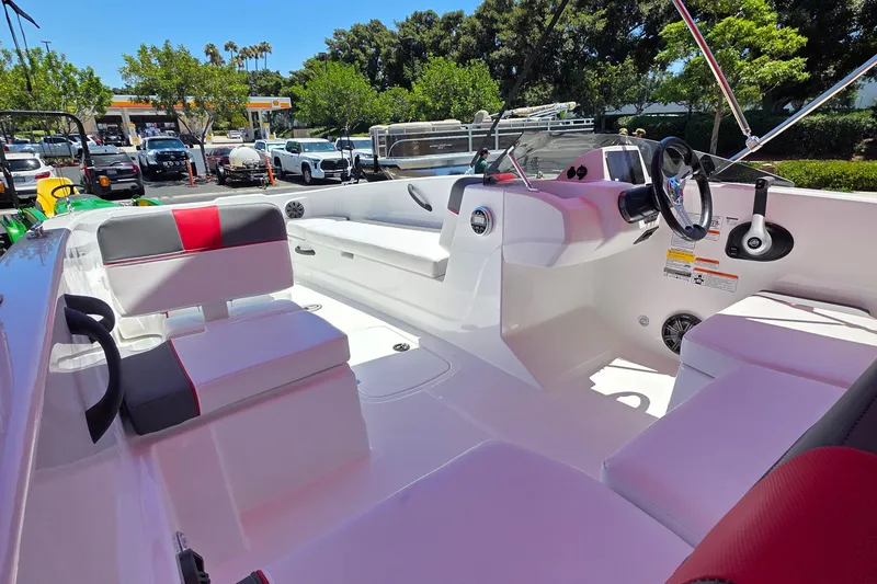 Slide: The Image of 2026 Tahoe T18 boat interior with modern seating and steering, parked outdoors. - 3