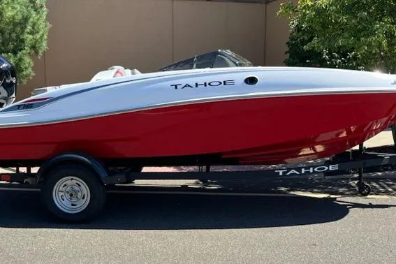 The Image of 2026 Tahoe T16 boat in red and white on a trailer, parked outdoors. - 0