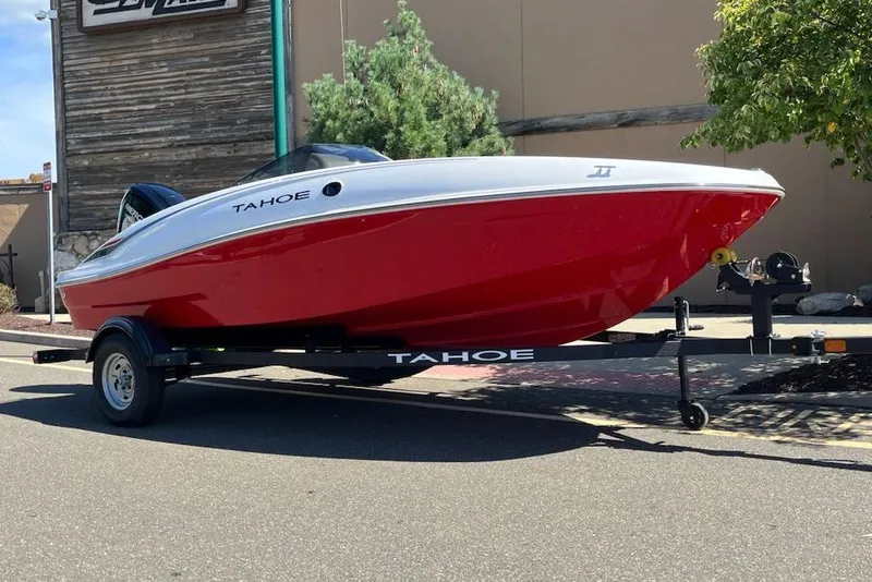 Slide: The Image of 2026 Tahoe T16 boat with red hull on trailer, parked outdoors. - 1
