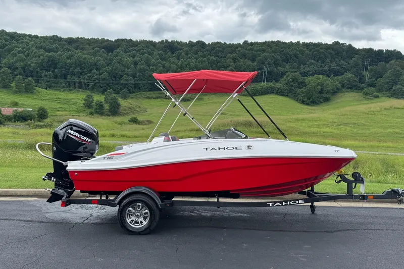 The Image of 2026 Tahoe T16 boat with red canopy on trailer, scenic green landscape background. - 0