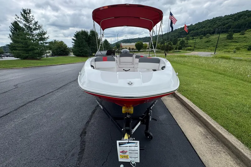 Slide: The Image of 2026 Tahoe T16 boat with red canopy on a trailer, parked on a paved road. - 3