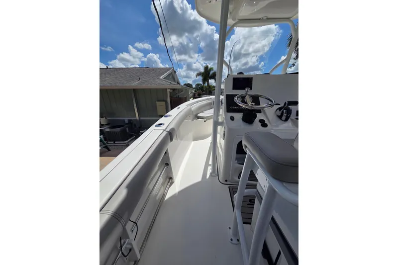 Slide: The Image of 2018 Sea Pro 219 Center Console boat interior with steering wheel and seating under blue sky. - 14