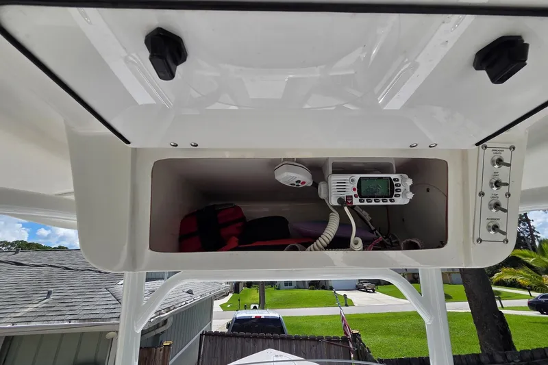 Slide: The Image of 2018 Sea Pro 219 Center Console storage compartment with radio and safety equipment. - 17