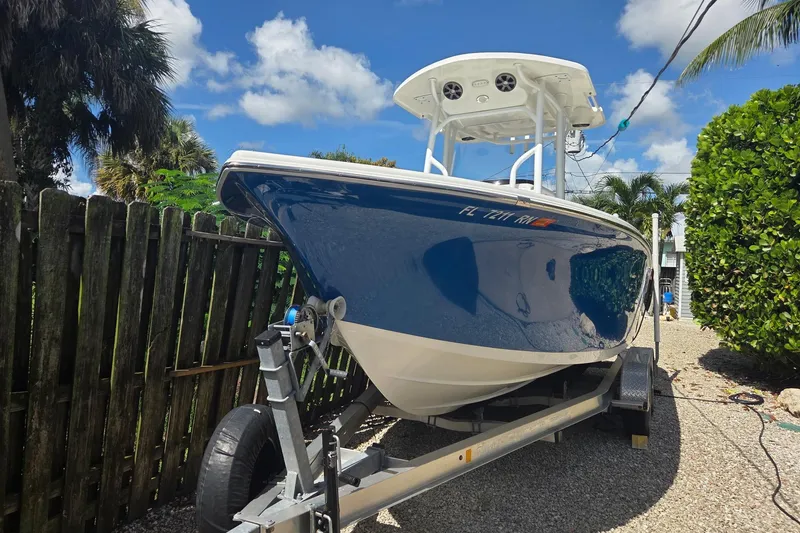 Slide: The Image of 2018 Sea Pro 219 Center Console boat on trailer, parked outdoors under blue sky. - 2