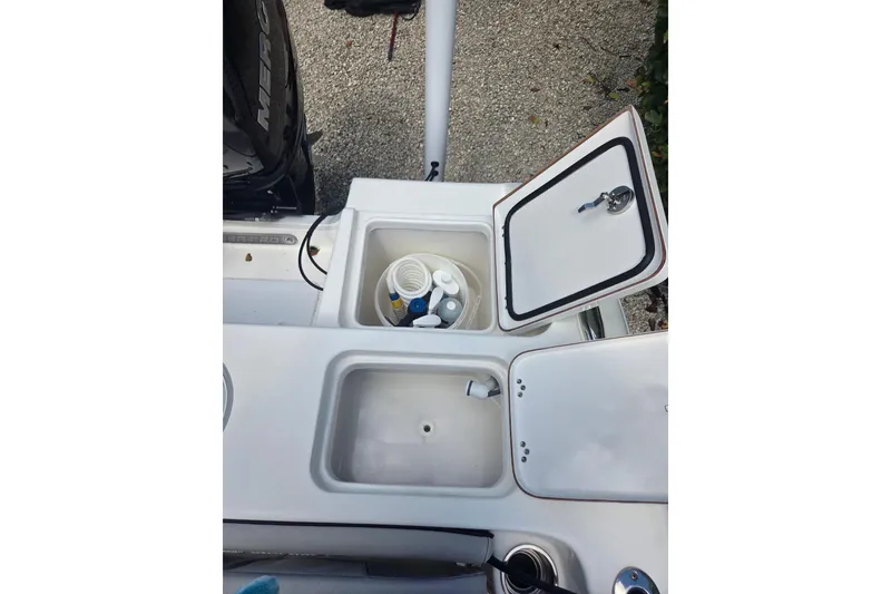 Slide: The Image of 2018 Sea Pro 219 Center Console boat storage compartments with open lids and accessories. - 20