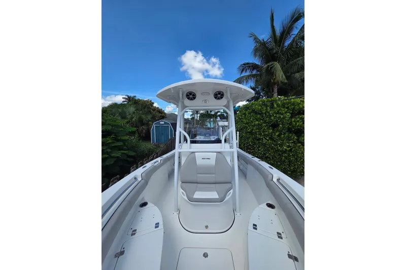 Slide: The Image of 2018 Sea Pro 219 Center Console boat with seating, surrounded by lush greenery and blue sky. - 23