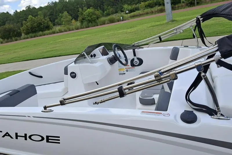 Slide: The Image of 2026 Tahoe T16 boat interior with steering wheel, seats, and metal railings, set against a grassy background. - 4