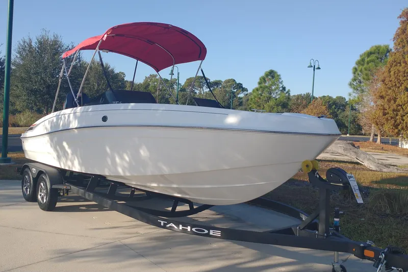 The Image of 2026 Tahoe T21 boat with red canopy on trailer, parked outdoors. - 0
