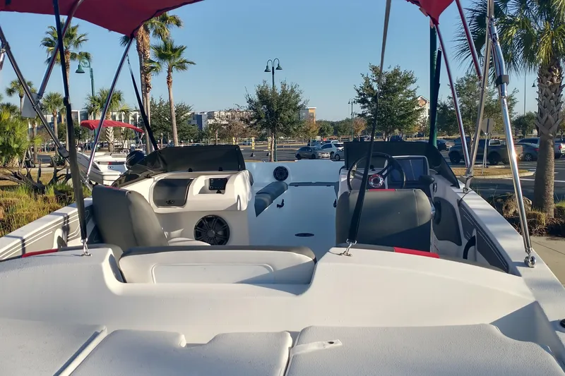 Slide: The Image of 2026 Tahoe T21 boat interior with canopy, parked outdoors under clear sky. - 3