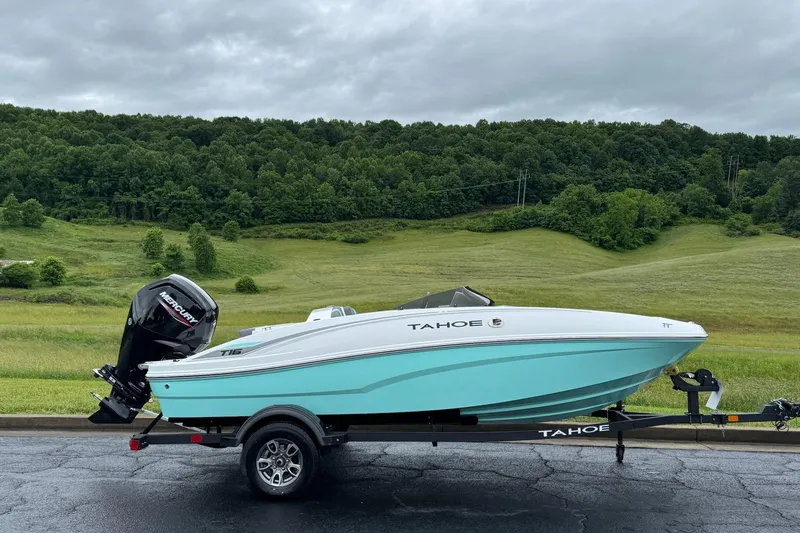 The Image of 2026 Tahoe T16 boat on trailer, scenic green landscape background. - 0
