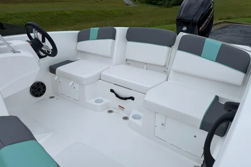 Slide: The Image of 2026 Tahoe T16 boat interior with white and gray seating, steering wheel, and cup holders. - 8