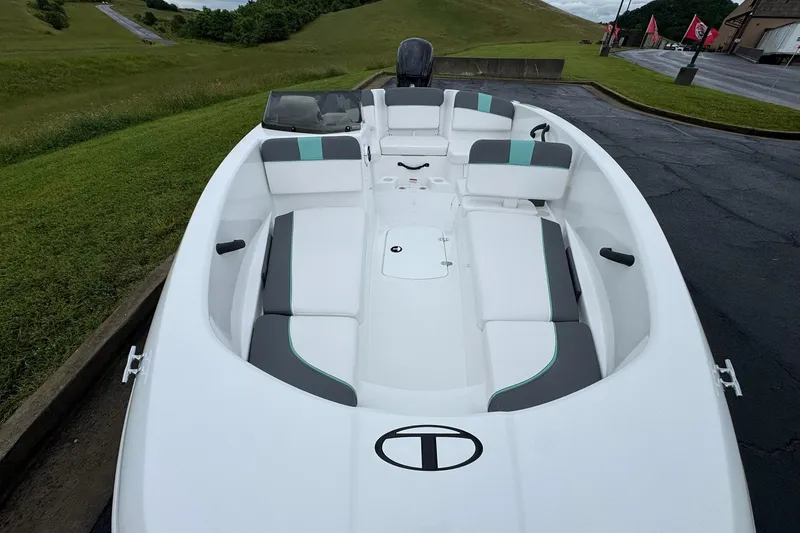 Slide: The Image of 2026 Tahoe T16 boat with sleek white and gray interior, parked outdoors. - 9