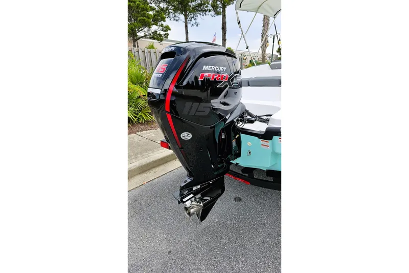 Slide: The Image of 2026 Tahoe T18 boat with canopy on trailer, parked near wooden fence. - 3