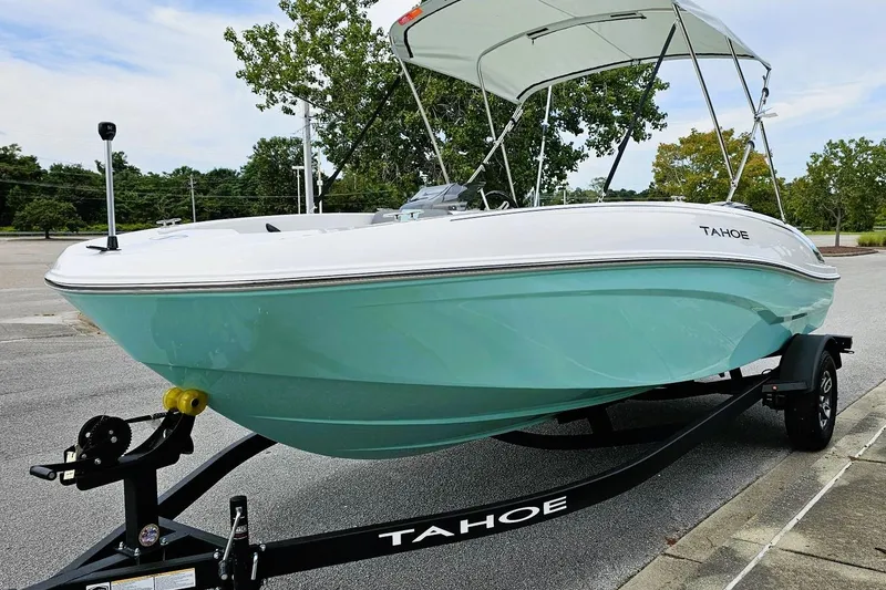 Slide: The Image of 2026 Tahoe T18 boat on trailer, parked on a street, showcasing sleek design. - 6