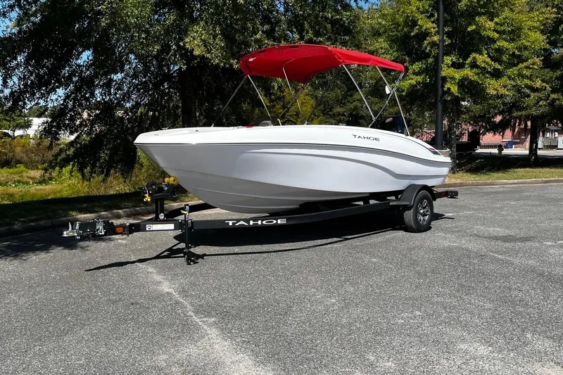 The Image of 2026 Tahoe T18 boat with red canopy on trailer, parked outdoors. - 1