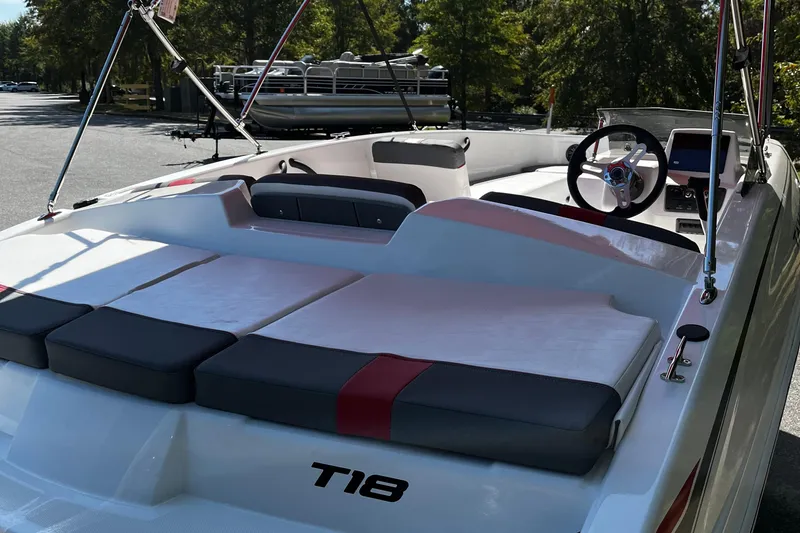 Slide: The Image of 2026 Tahoe T18 boat interior with seating and steering wheel, parked outdoors. - 5