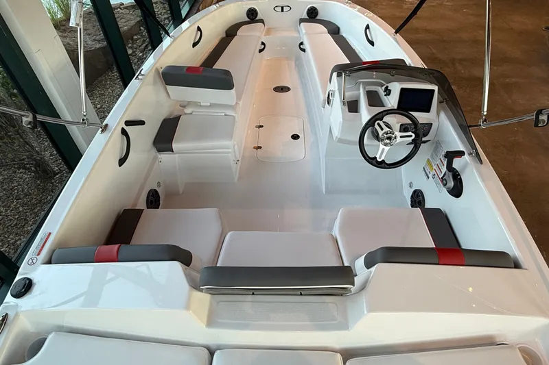 Slide: The Image of 2026 Tahoe T18 boat interior with seating, steering wheel, and dashboard in a showroom. - 4