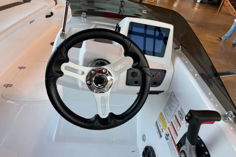 Slide: The Image of Steering wheel and dashboard of 2026 Tahoe T18 boat, featuring modern controls and display. - 5