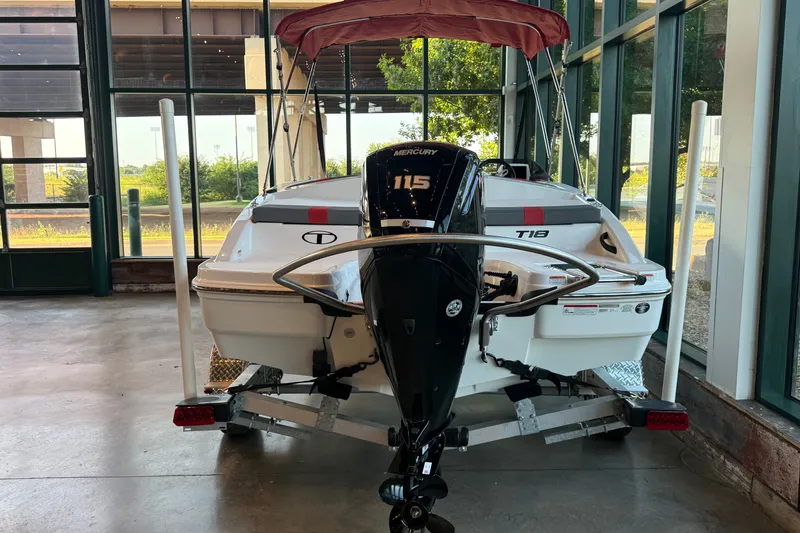 Slide: The Image of 2026 Tahoe T18 boat with Mercury 115 engine displayed indoors. - 12