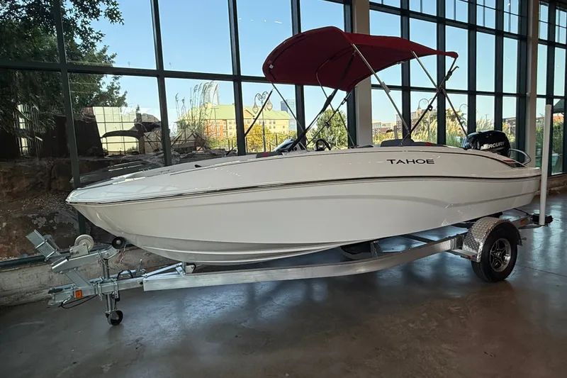 Slide: The Image of 2026 Tahoe T18 boat with red canopy on a trailer, displayed indoors. - 10