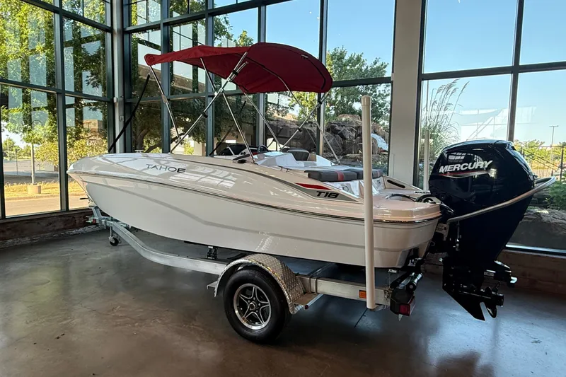 Slide: The Image of 2026 Tahoe T18 boat with red canopy and Mercury outboard motor in showroom. - 9