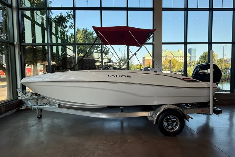 Slide: The Image of 2026 Tahoe T18 boat on trailer in showroom with large windows. - 8