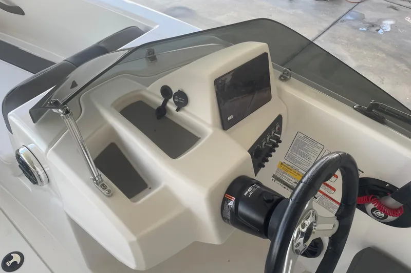 Slide: The Image of 2026 Tahoe T16 boat dashboard with steering wheel, controls, and display screen. - 10