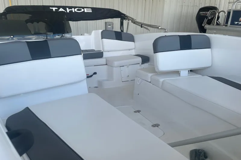 Slide: The Image of 2026 Tahoe T16 boat interior with white and gray seating, under a covered area. - 7