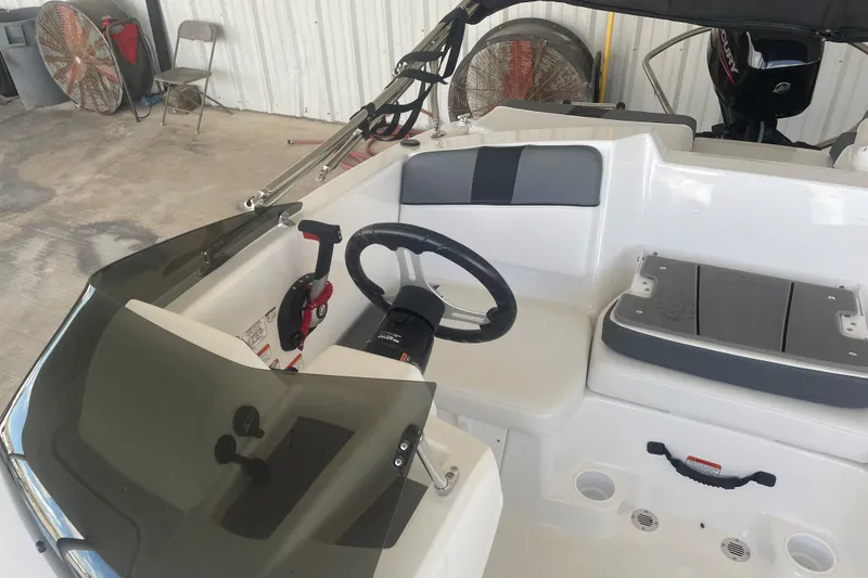 Slide: The Image of 2026 Tahoe T16 boat interior with steering wheel and seating in a garage setting. - 9