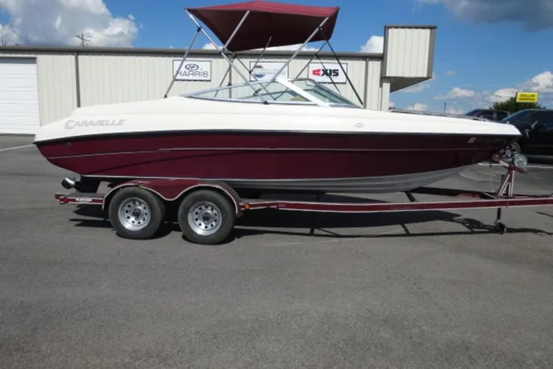 The Image of 1995 Caravelle 206 boat on trailer, maroon and white, parked outdoors. - 0