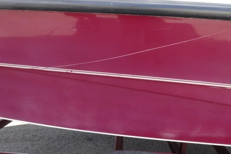 Slide: The Image of Red Caravelle 206 boat hull from 1995 with visible scratches. - 11