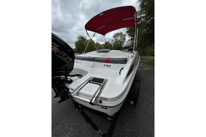 Slide: The Image of 2026 Tahoe T18 boat with red canopy and sleek design on a trailer. - 4