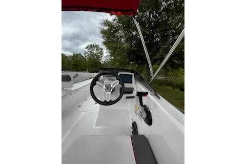 Slide: The Image of 2026 Tahoe T18 boat interior with steering wheel and control panel, surrounded by lush greenery. - 5