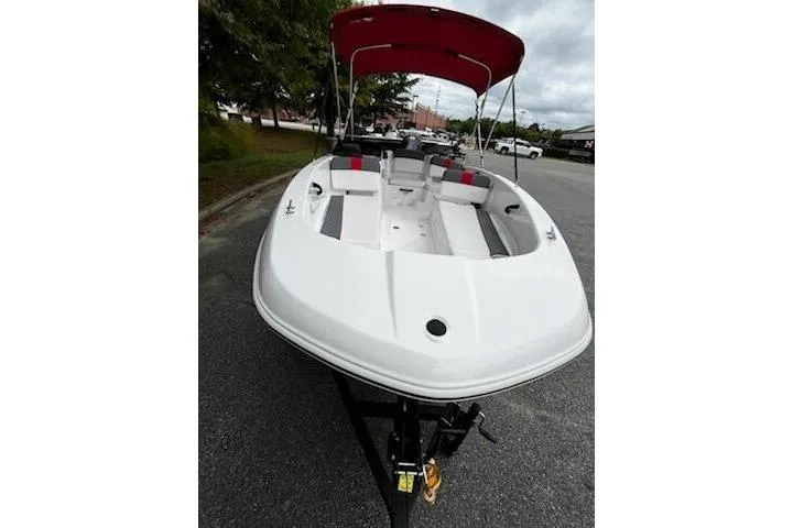 Slide: The Image of 2026 Tahoe T18 boat with red canopy, parked on a street. - 6