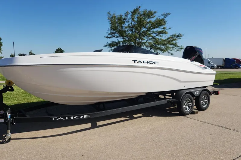 Slide: The Image of 2026 Tahoe T21 boat on trailer, parked outdoors under clear blue sky. - 1