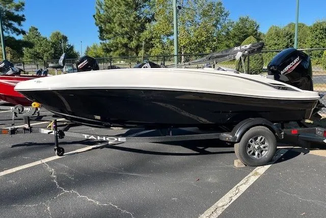 The Image of 2026 Tahoe T16 boat on trailer, black and white design, parked outdoors. - 0
