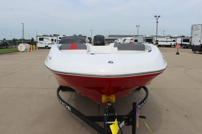 Slide: The Image of 2026 Tahoe T16 boat in parking lot, front view with trailers in background. - 2