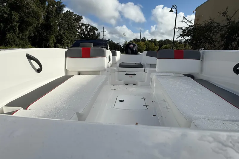 Slide: The Image of 2026 Tahoe T18 boat interior with seating and storage, under a partly cloudy sky. - 2